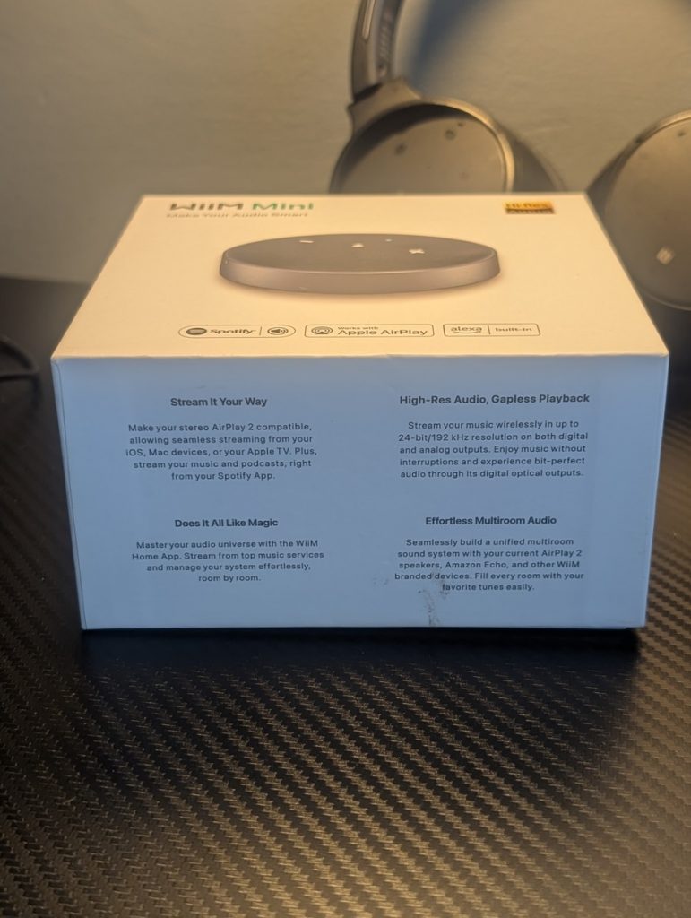 Retail box of the WiiM Mini streamer showing product features like AirPlay 2, Hi-Res Audio, and gapless playback.