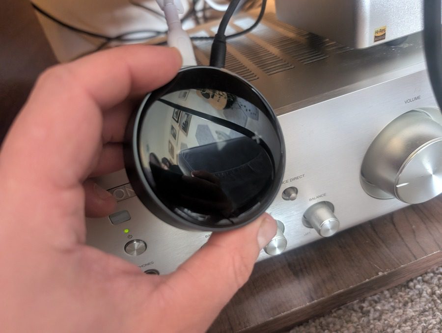 WiiM Mini shown in hand to display its compact form factor